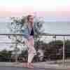 Cream Valley Legwarmers on woman standing against a fence - 1