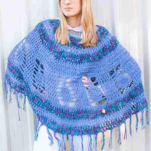 Pineapple Poncho Crochet Pattern - Blue version on Model against white wall with hands on hips