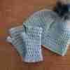 Trellis Beanie and Mitts set in grey with faux pom on beanie. Flat lay on wooden board