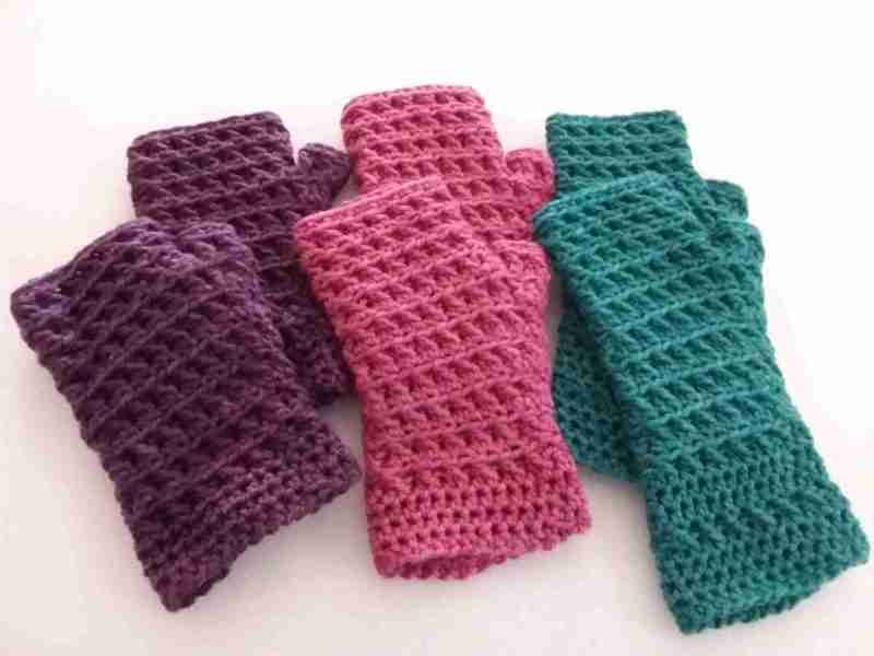 3 pairs of Trellis-Mitts in Sally Ridgway Yarns - Aubergine, Apple Blossom & Sage. Flat lay on white background