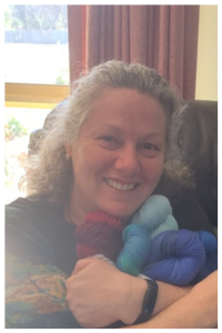 Fiona Langtry, Chief Crochet Designer & CEO for ReVeDesignCo hugging an arm full of yarn - Mothers' Day 2020